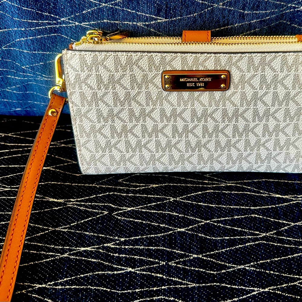 Michael Kors tan zip around wristlet with gold hardware.